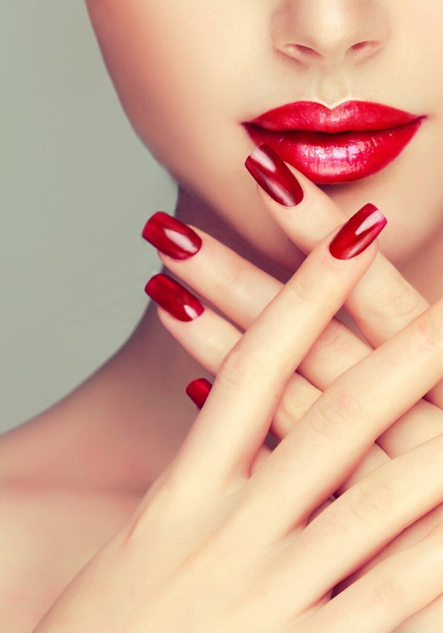 Beautiful girl showing red  manicure nails . makeup and cosmetics